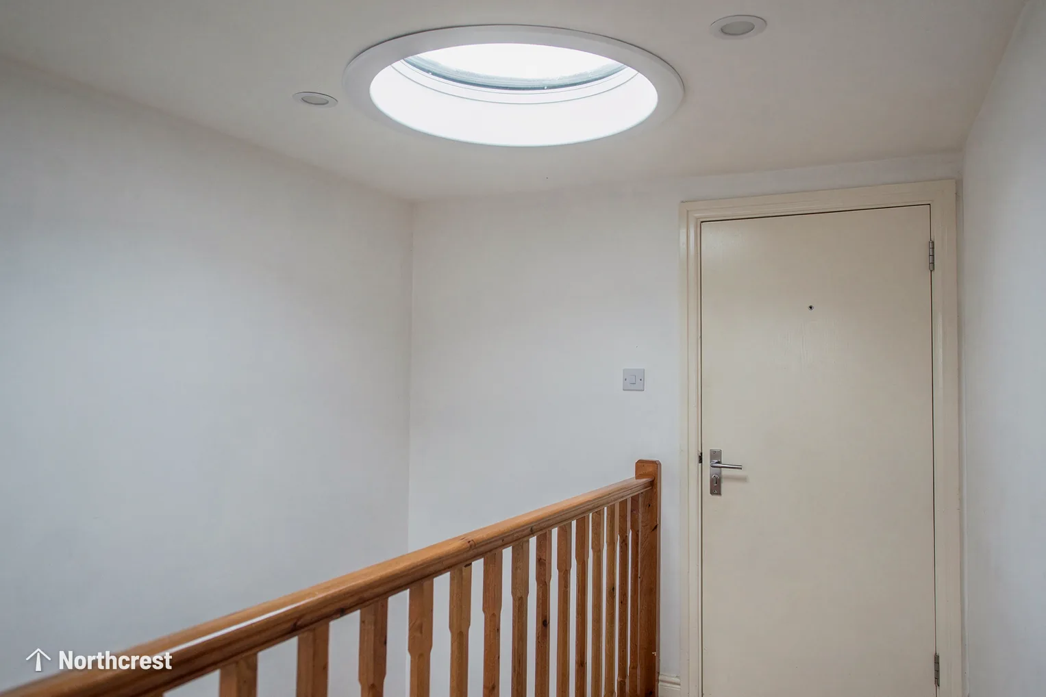 Round sun tunnel diffuser set in a landing ceiling above a timber banister